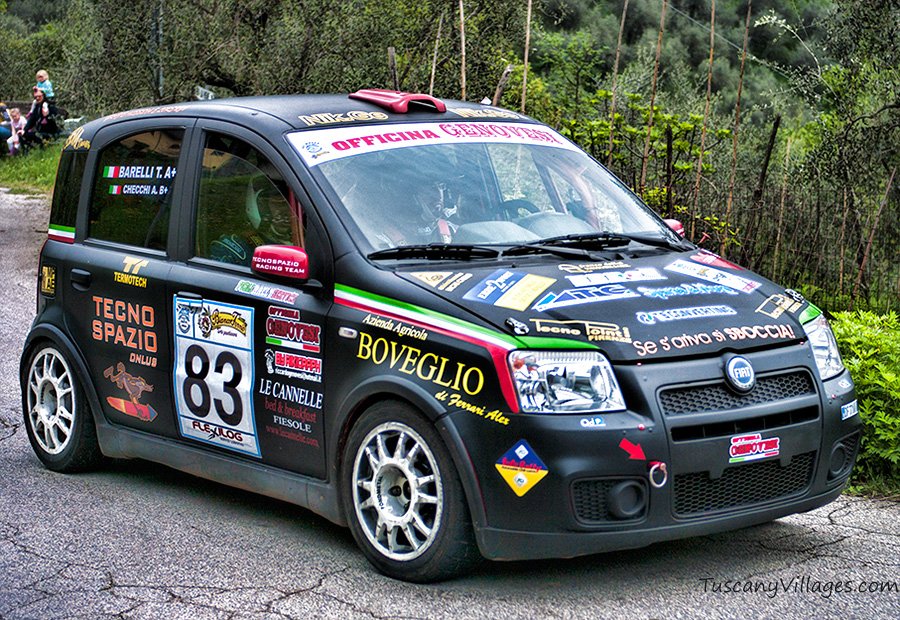 A black rally car on the road through Castelvecchio