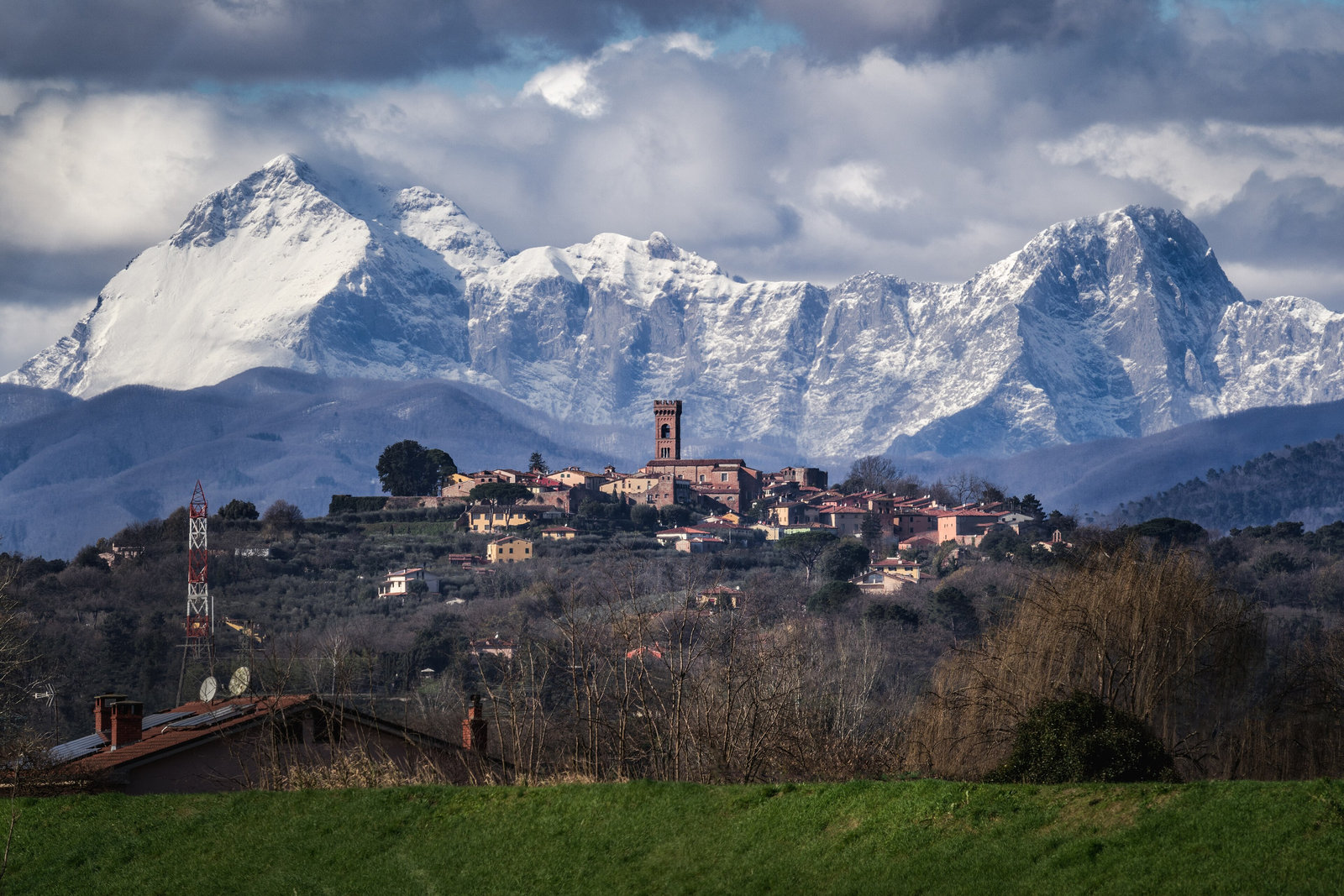 The walled hill village of Montecarlo on its ridge, with the snowy Apuan Alps behind
