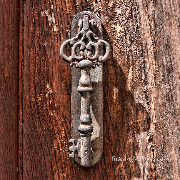 An old iron door knocker on weathered wood