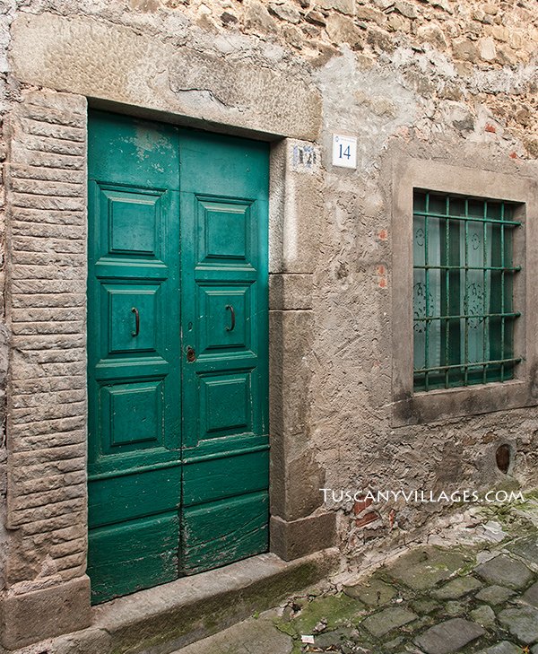 A green door and window in an old stone house in Pontito