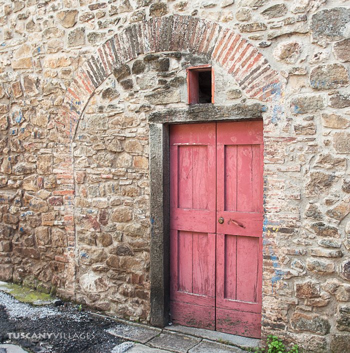 A red door set in an old stone arch in Sorana