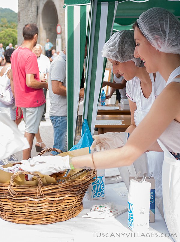 Village ladies serving beccutini at the festa