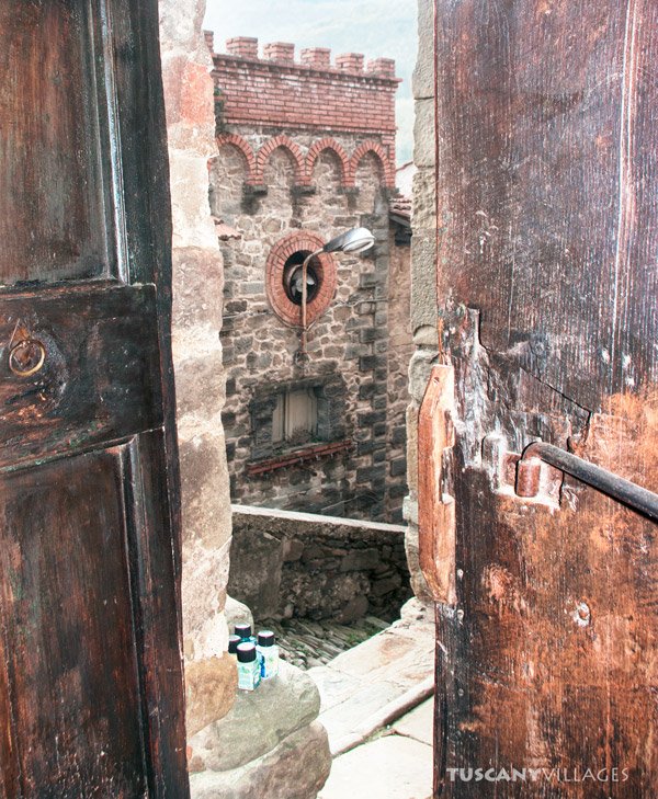 Old wooden doors framing a crenellated village tower