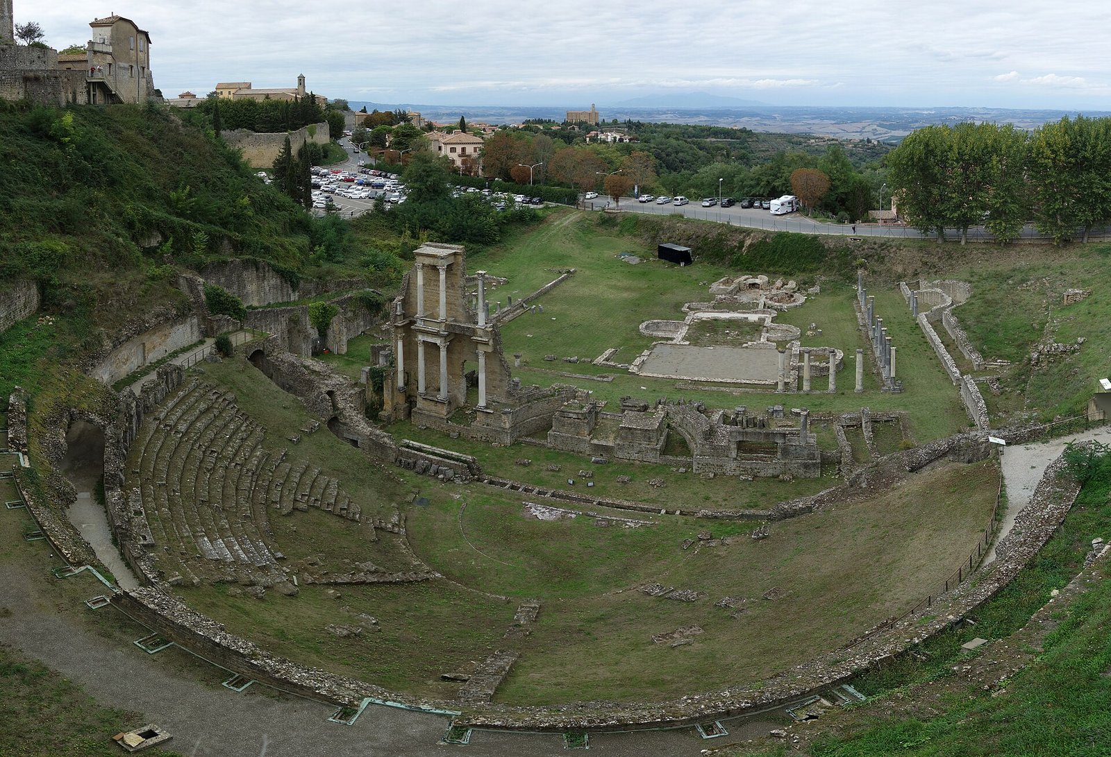 The stone seats and columns of the Roman theatre below the walls of Volterra